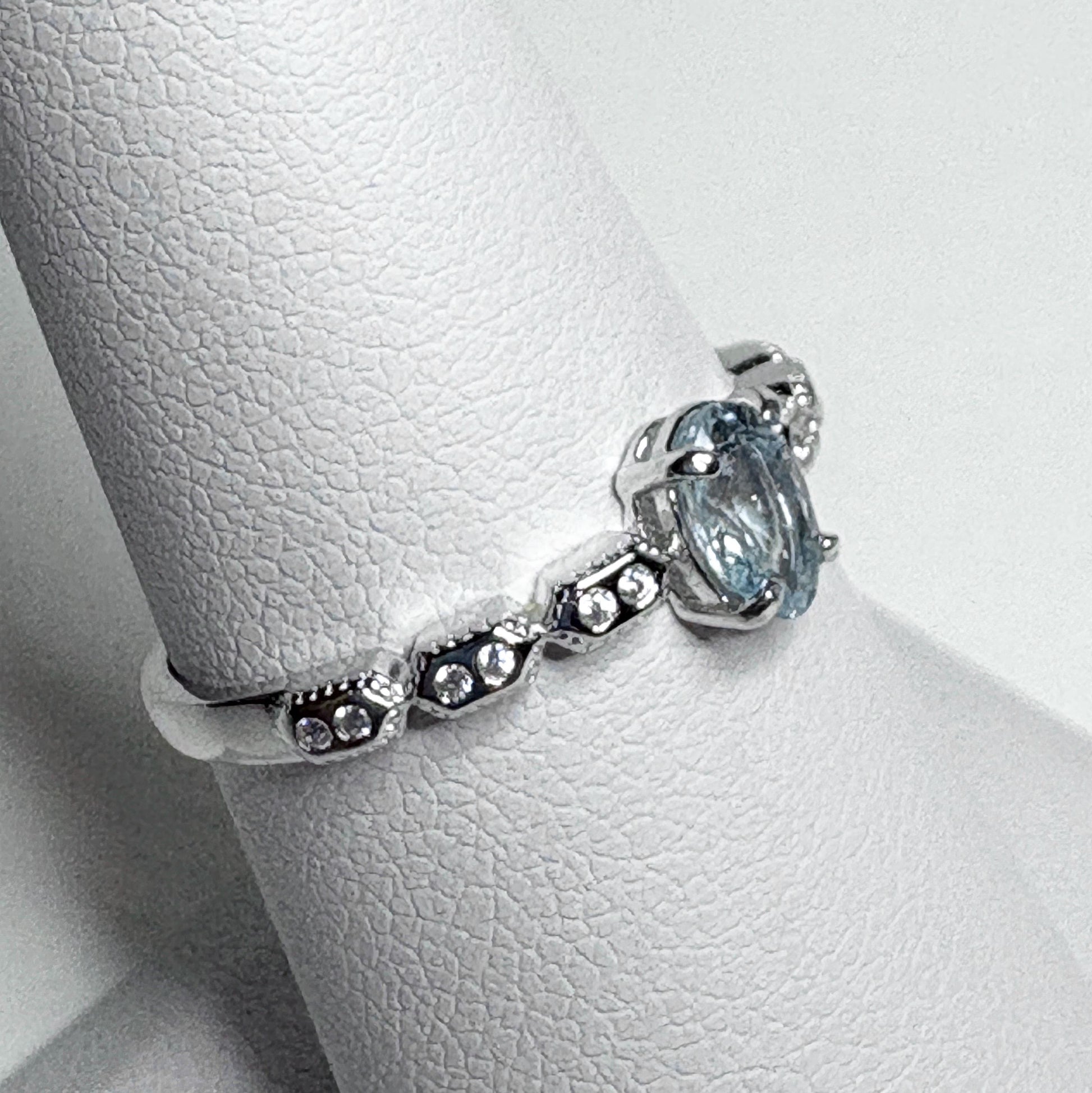 Sterling silver ring with a light blue oval tourmaline and crystal accents.