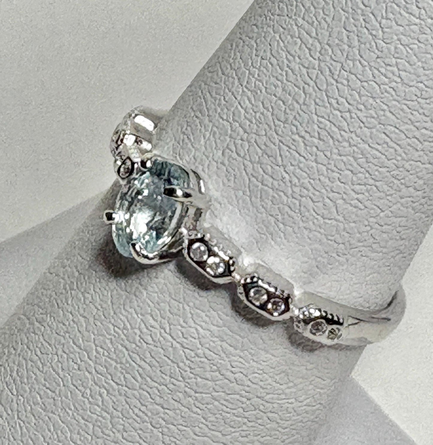 Sterling silver ring with oval light blue tourmaline and crystal accents.