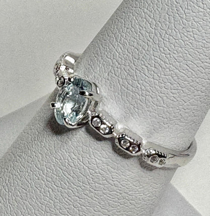 Sterling silver ring with oval light blue tourmaline and crystal accents.