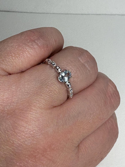 Sterling silver ring with a light blue oval tourmaline and crystal accents.