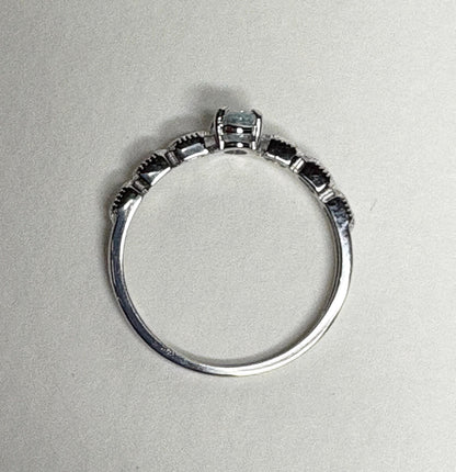 Sterling silver ring with a light blue oval tourmaline and crystal accents.
