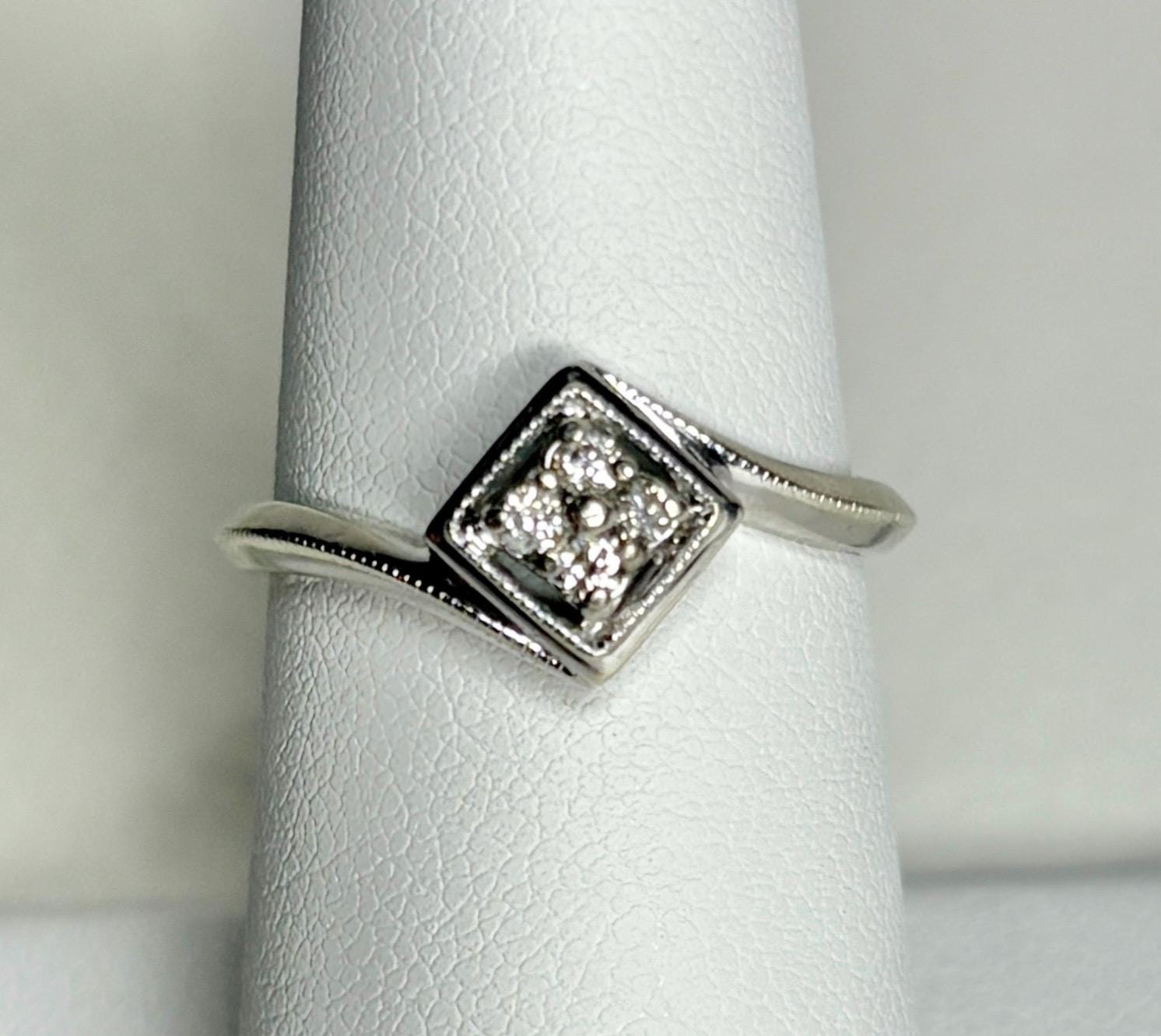 A 10k white gold ring with a square cluster of natural diamonds.