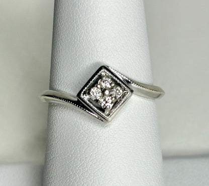 A 10k white gold ring with a square cluster of natural diamonds.