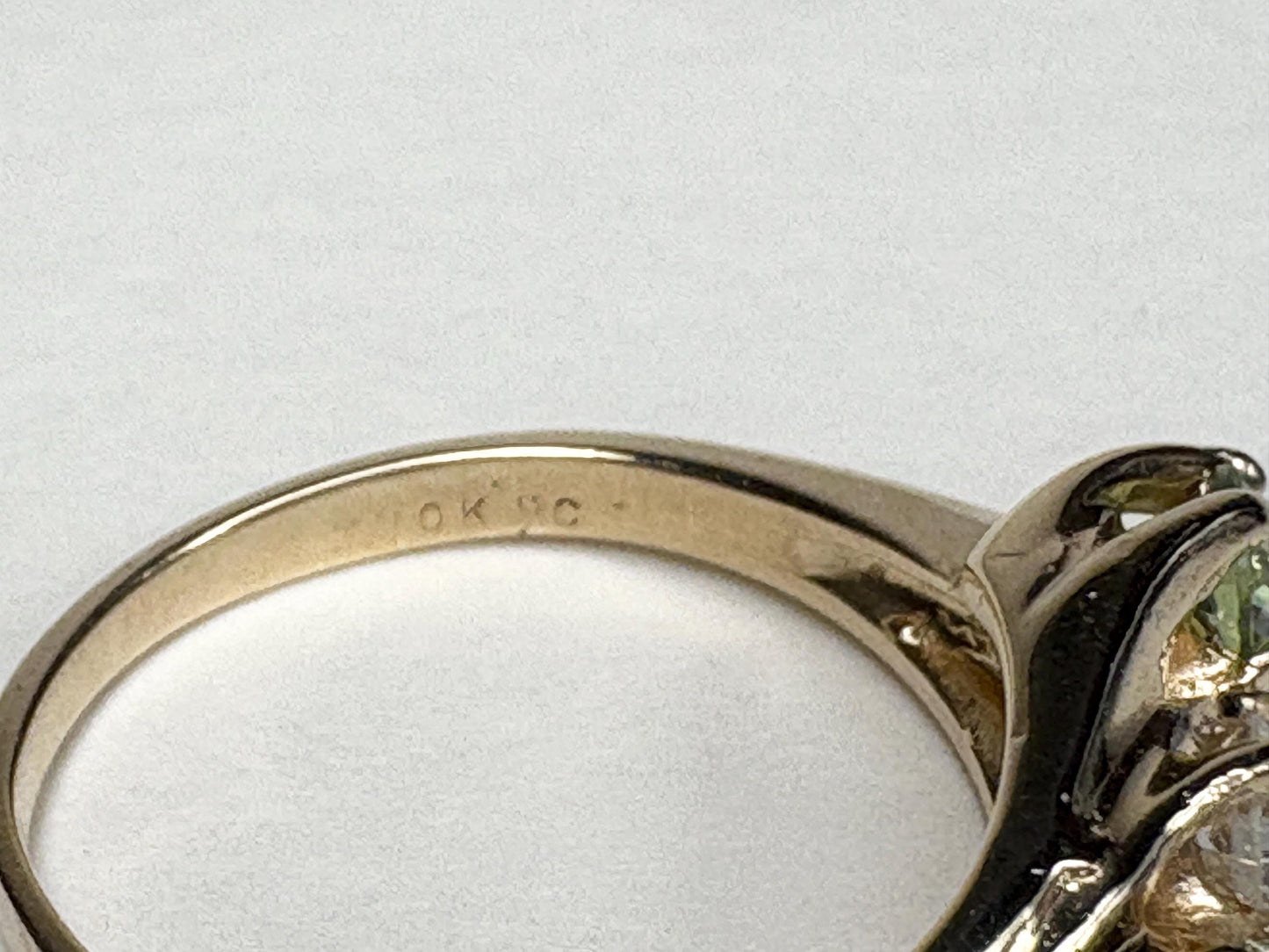 A 10k gold ring with a diamond and two demantoid garnets.