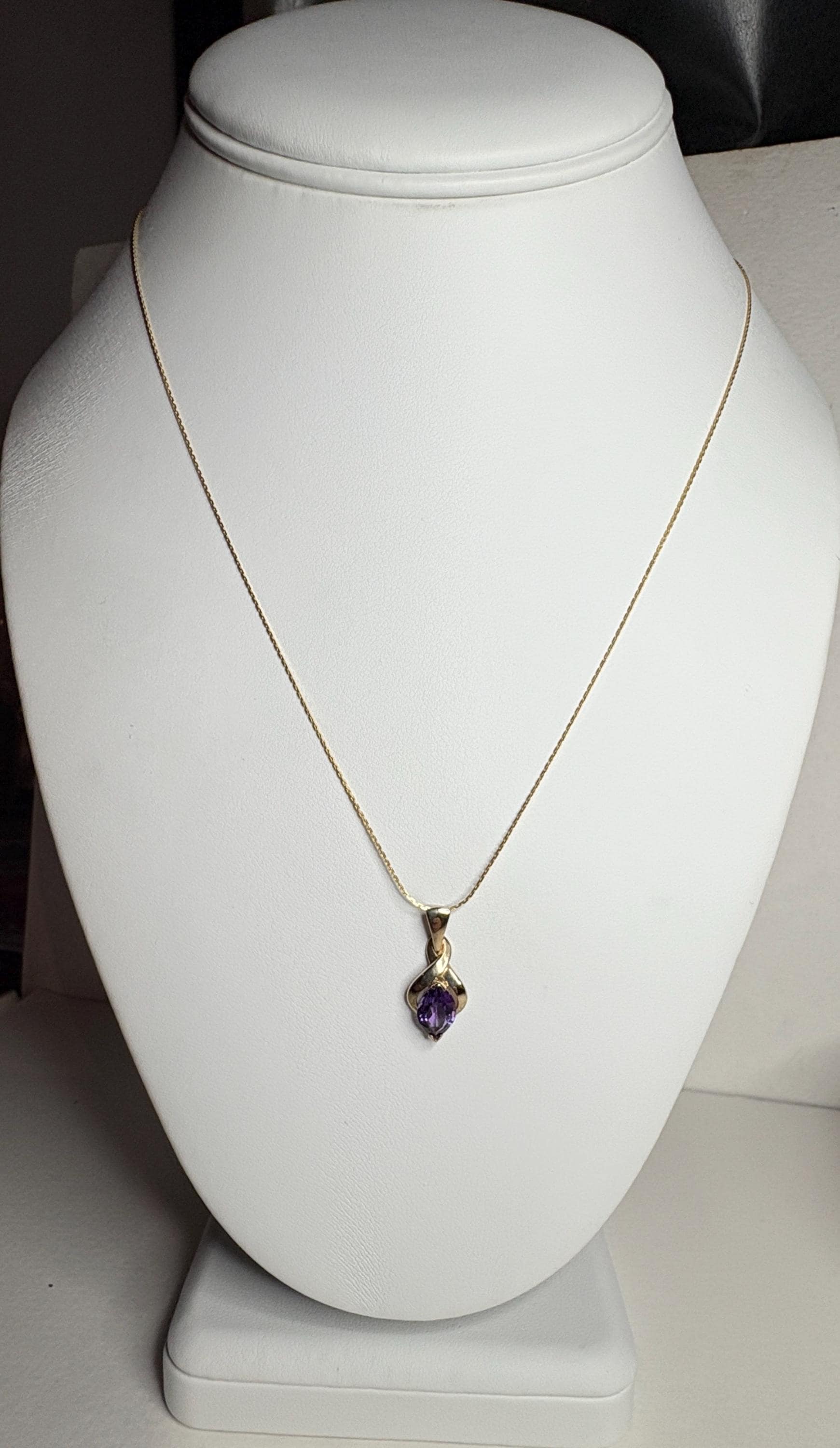 A vintage 9k gold necklace with a marquise-shaped amethyst pendant.