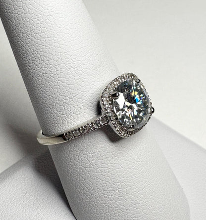 Oval moissanite halo ring with diamond accents in white gold.