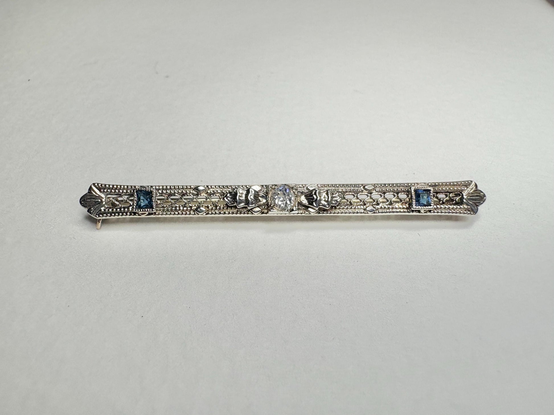 Antique 10k white gold bar brooch with a diamond and simulated sapphires.