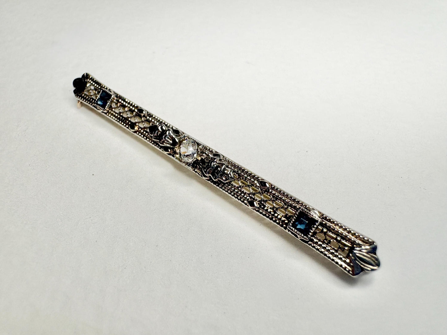 Antique bar brooch with old mine cut diamond and simulated sapphires in 10k white gold.