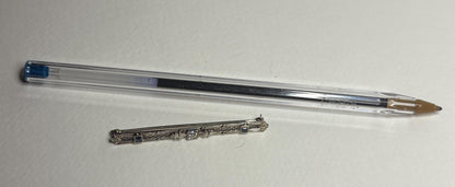 Antique 10k white gold bar brooch with an old mine cut diamond and simulated sapphires.