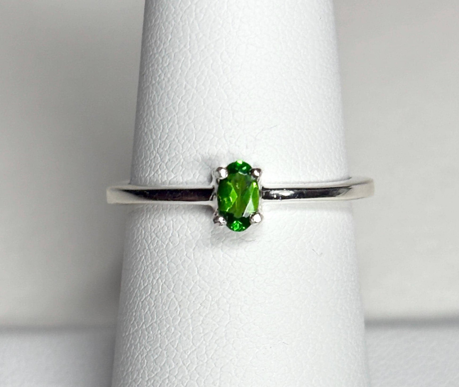 Sterling silver ring with a 3x5mm oval chrome diopside gemstone.
