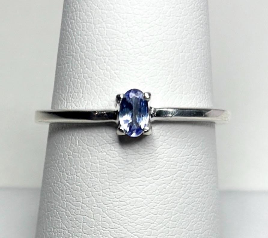 Sterling silver ring with a small oval tanzanite gemstone.