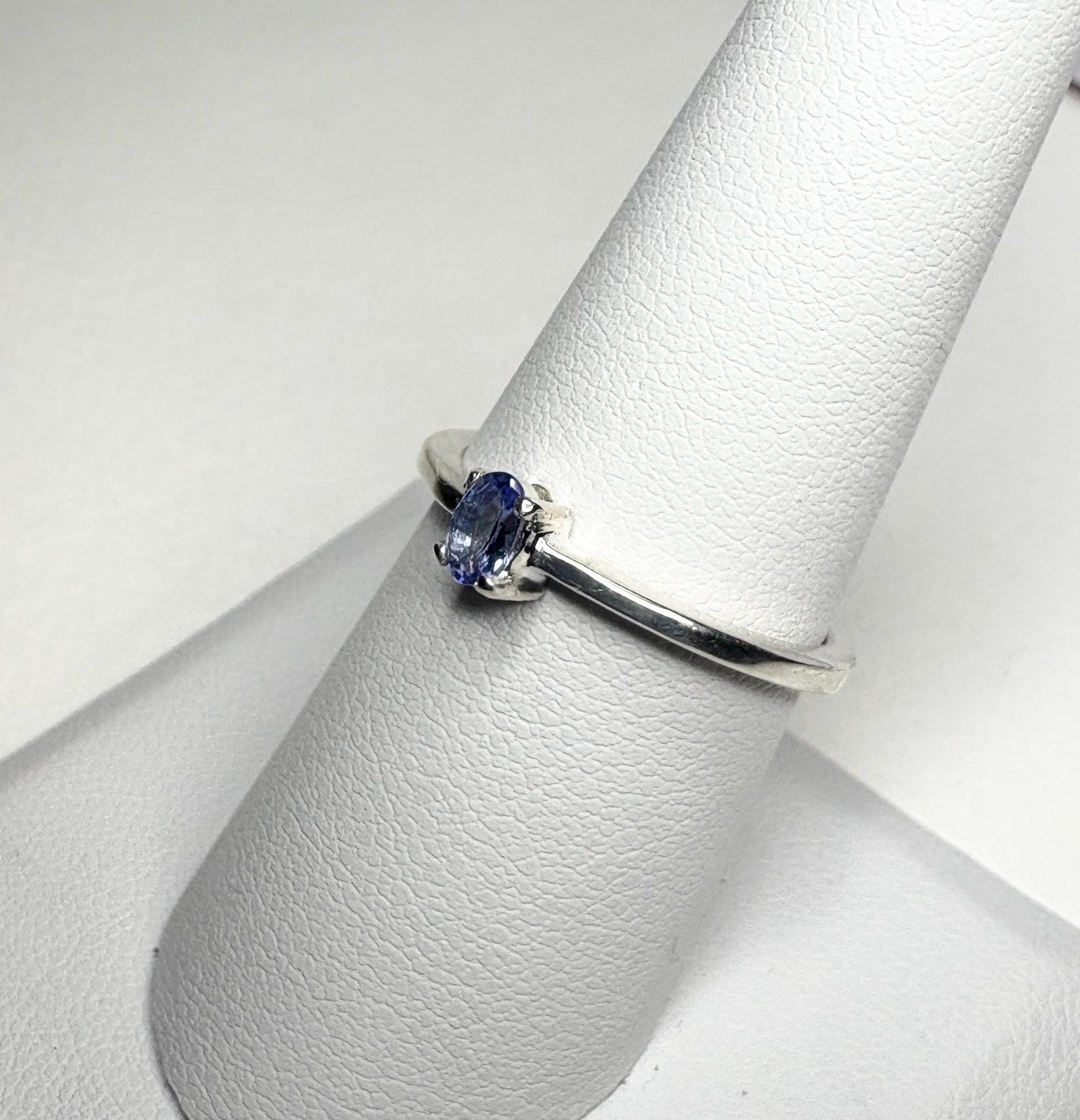 Sterling silver ring with a small oval tanzanite gemstone.