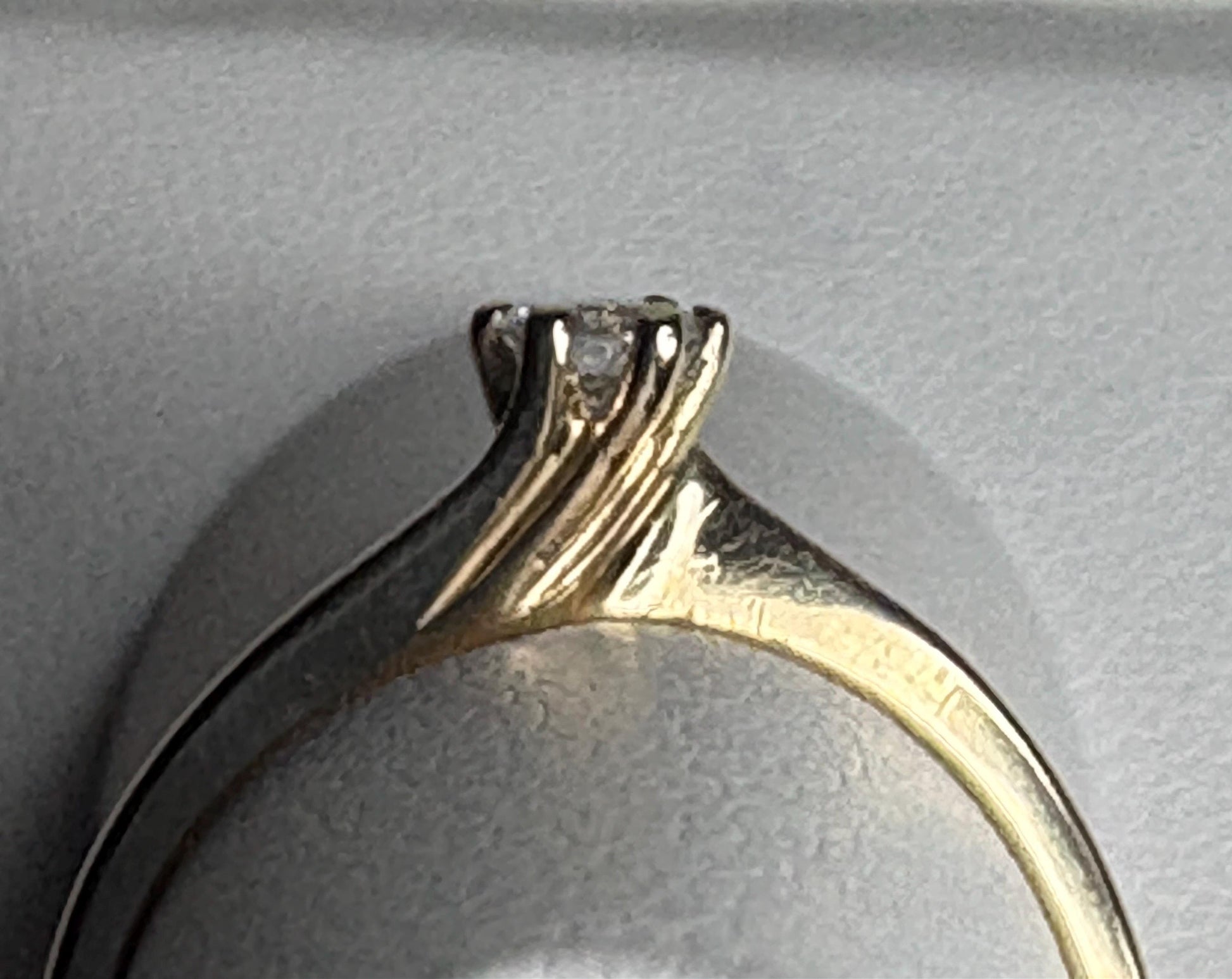 Natural diamond solitaire ring with a twist design in solid 14k gold.