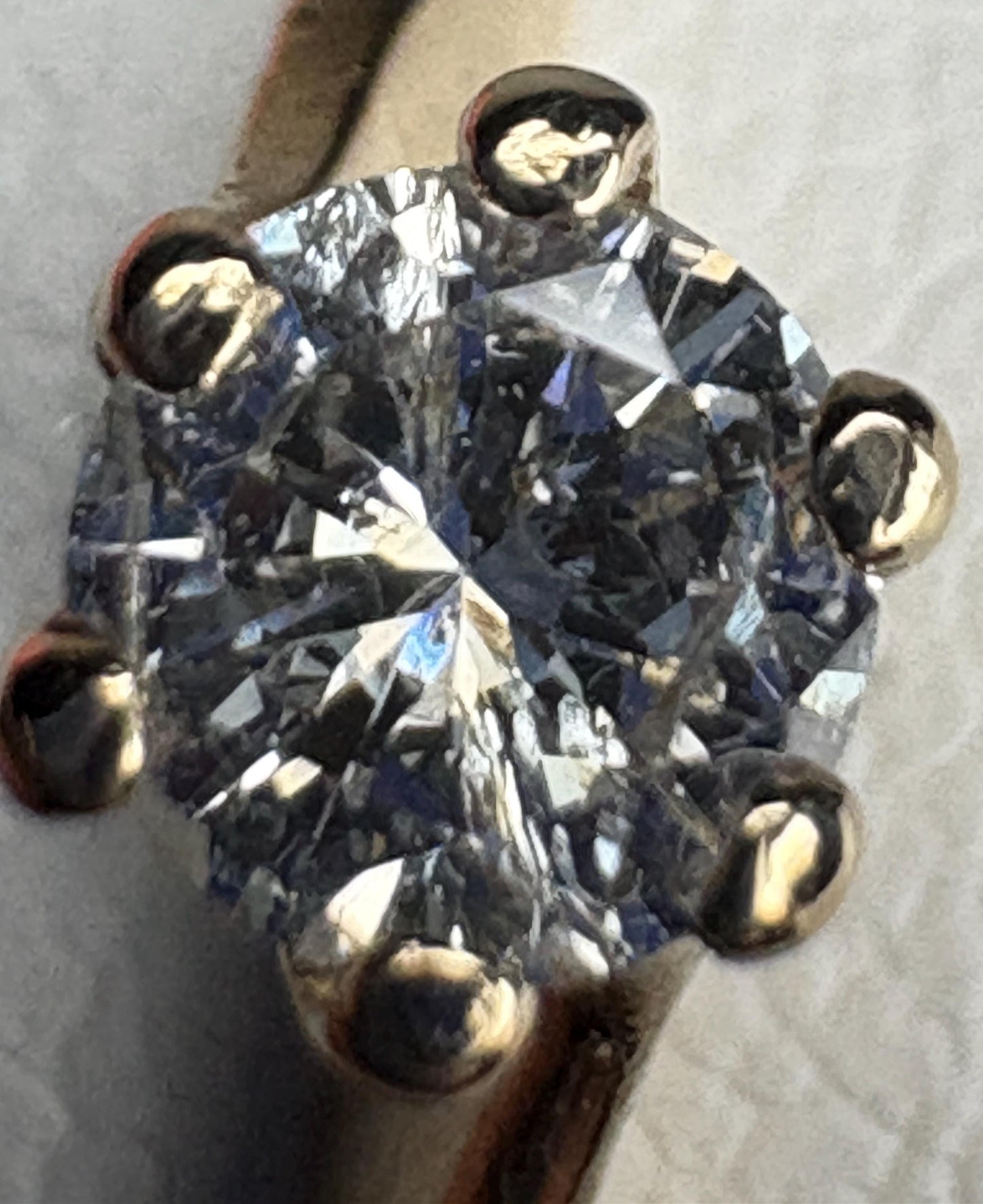 A solitaire diamond ring with a twist design in 14k gold.