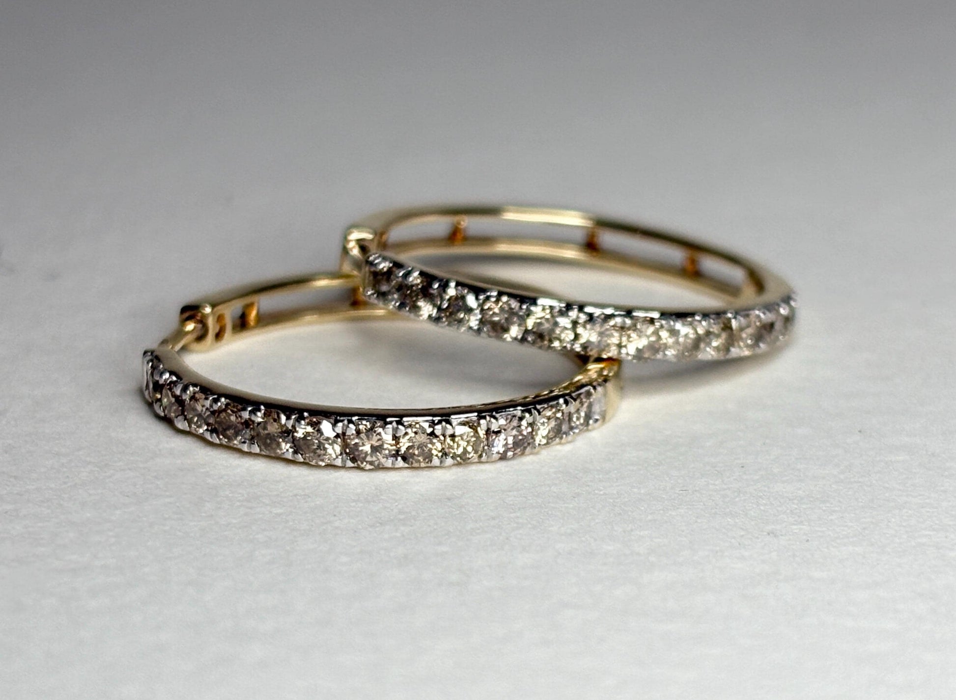 10k gold hoop earrings with channel-set brown diamonds.