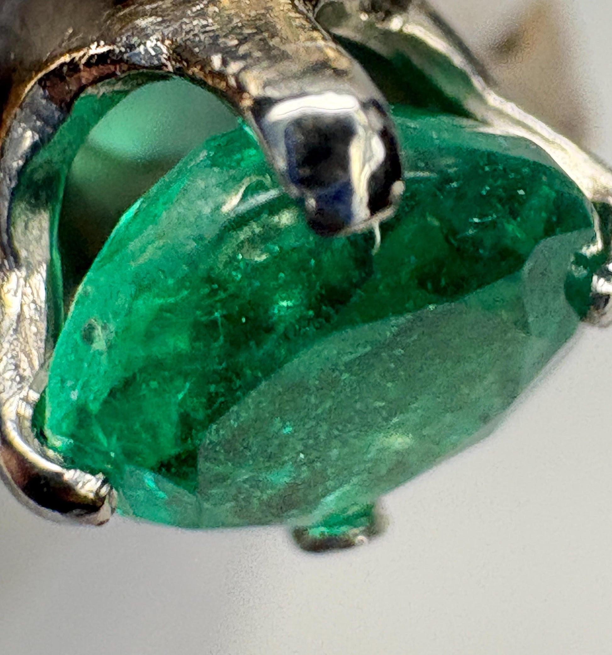 A vintage handmade 14k gold ring featuring a free-form emerald and single cut diamonds.
