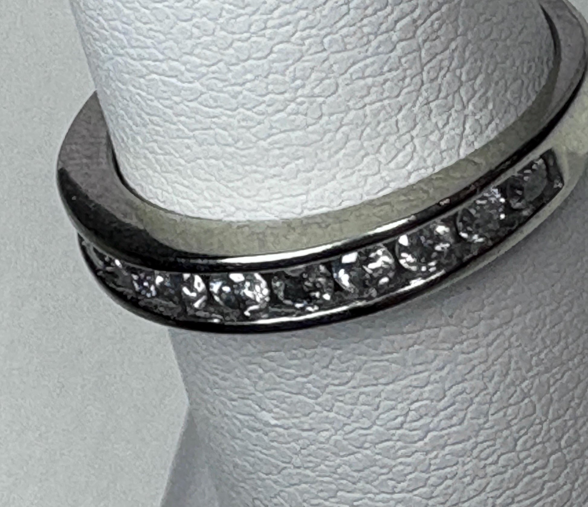 A white gold anniversary band ring with channel-set diamonds.