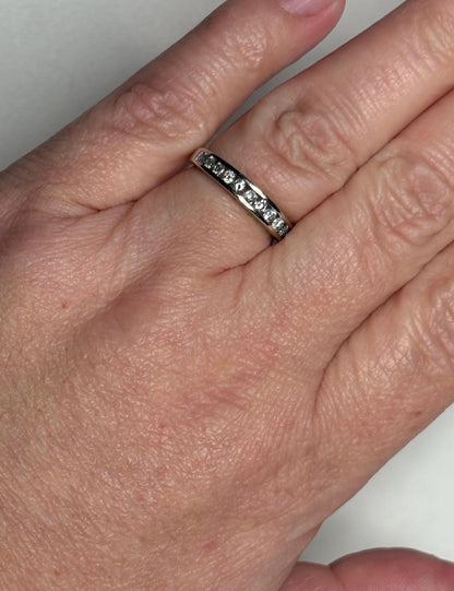 A white gold anniversary band ring with channel-set diamonds.