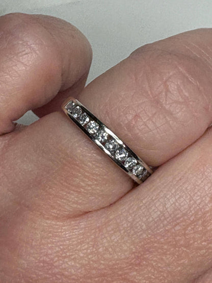 A 10k white gold anniversary band ring with channel-set diamonds.