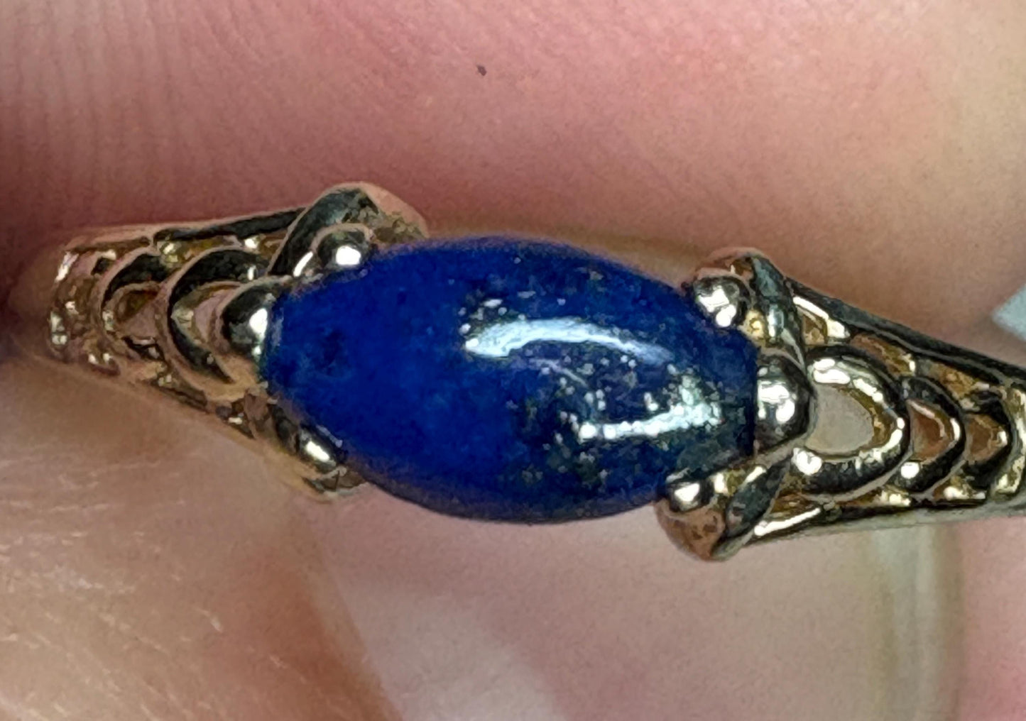 A lapis lazuli marquise cabochon set in a 14k gold east west ring.