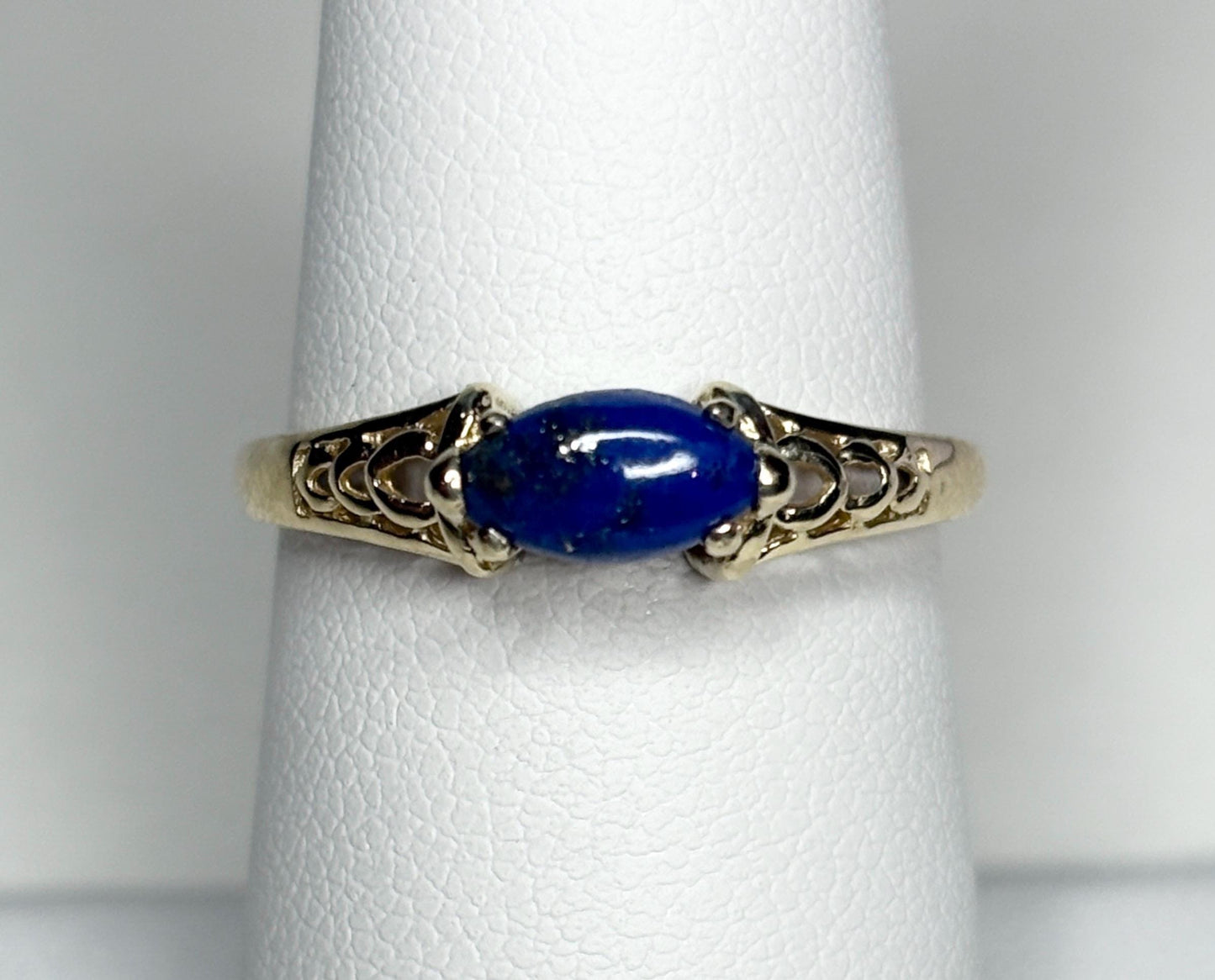 A 14k gold ring with an east-west set marquise lapis lazuli cabochon.