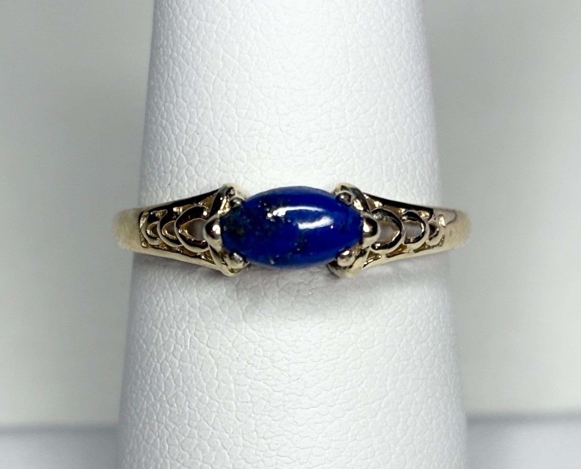 A 14k gold ring with an east-west set marquise lapis lazuli cabochon.