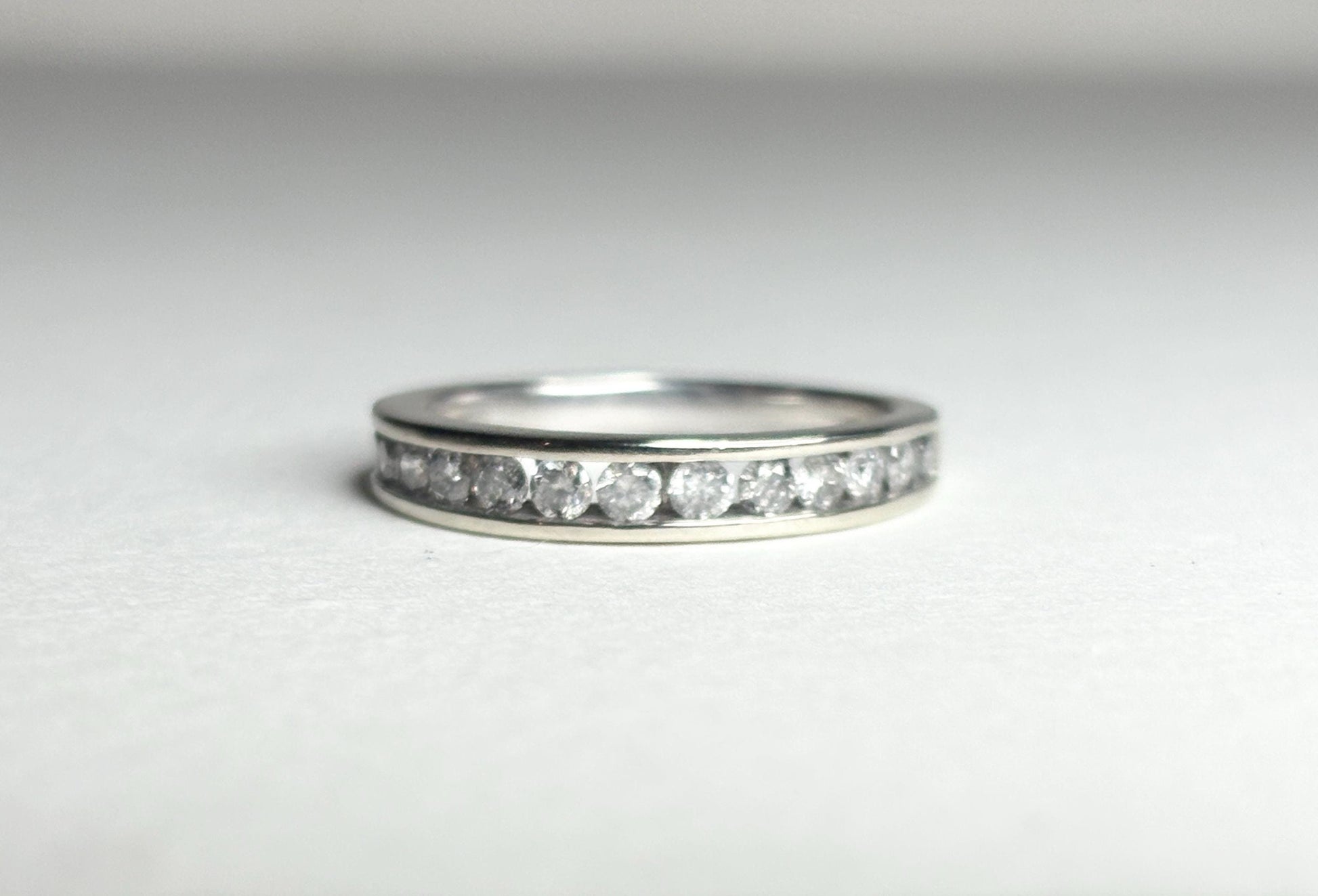 A white gold band ring with channel-set diamonds.