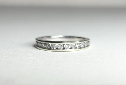 A white gold band ring with channel-set diamonds.