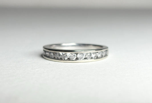 A white gold band ring with channel-set diamonds.