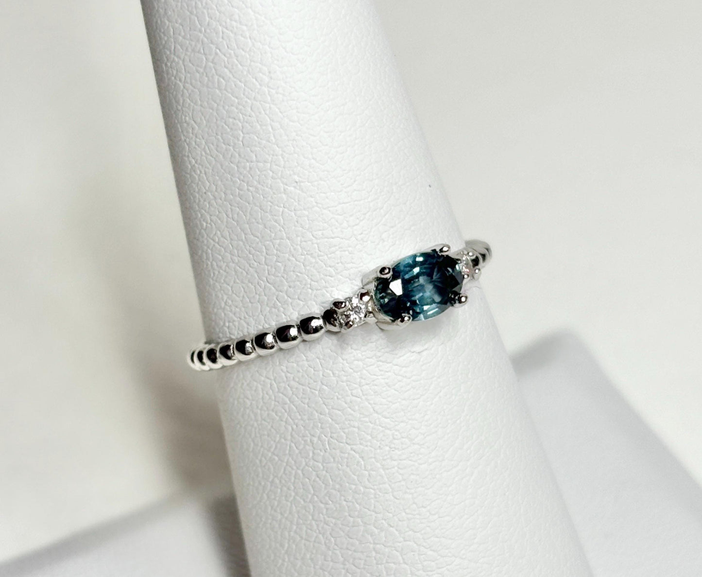 Sterling silver ring with a Montana sapphire and diamonds on a beaded band.