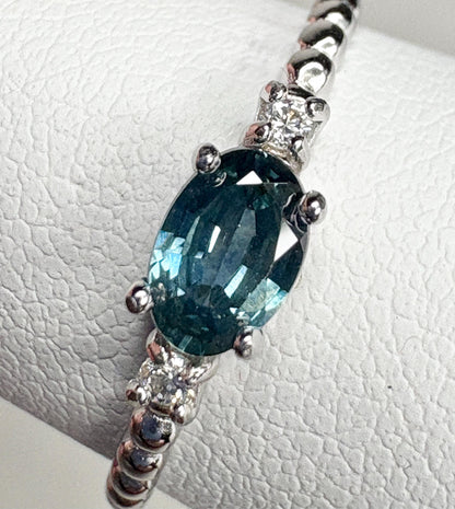 Sterling silver ring with oval Montana sapphire and two diamonds on a beaded band.