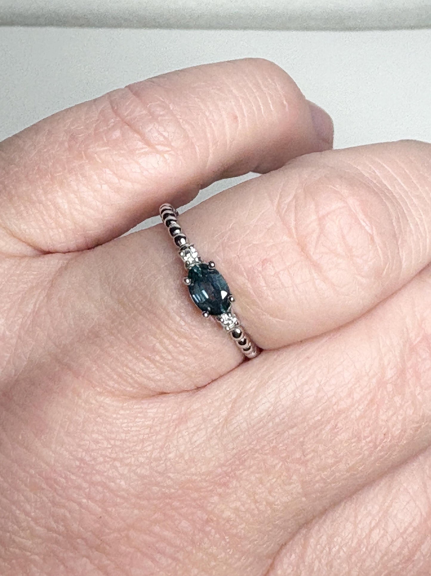 Sterling silver ring with oval Montana sapphire and diamonds on a beaded band.