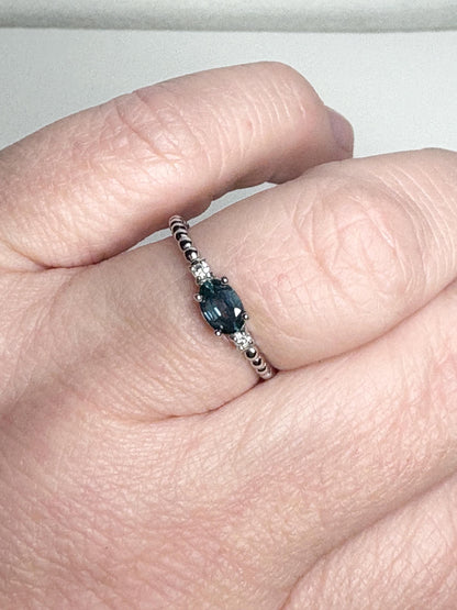 Sterling silver ring with oval Montana sapphire and diamonds on a beaded band.