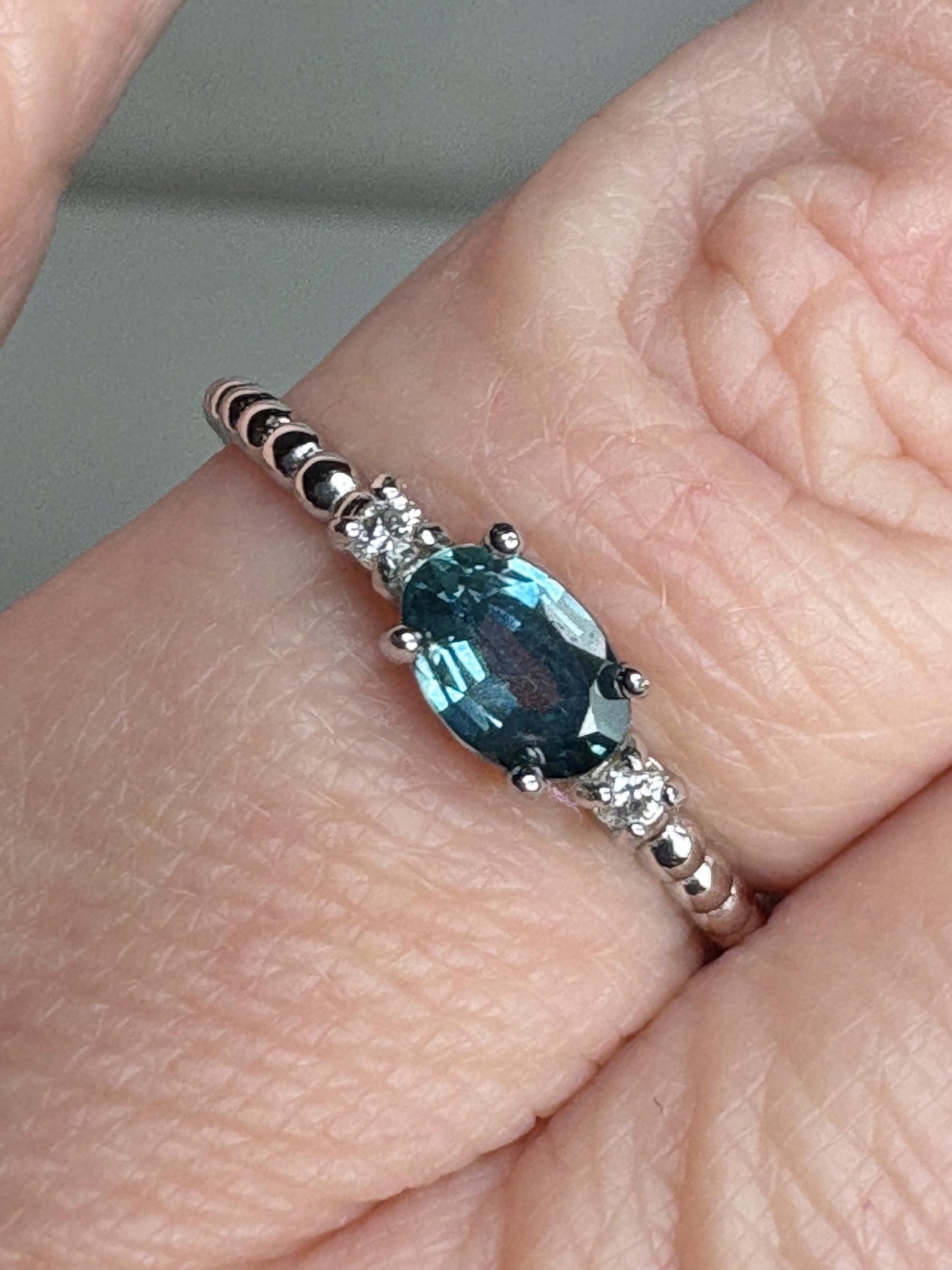 Sterling silver ring with oval Montana sapphire and diamonds on a beaded band.