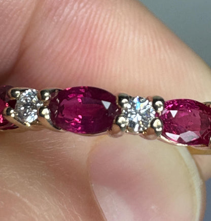 A 14k gold band ring with oval red sapphires and diamonds.