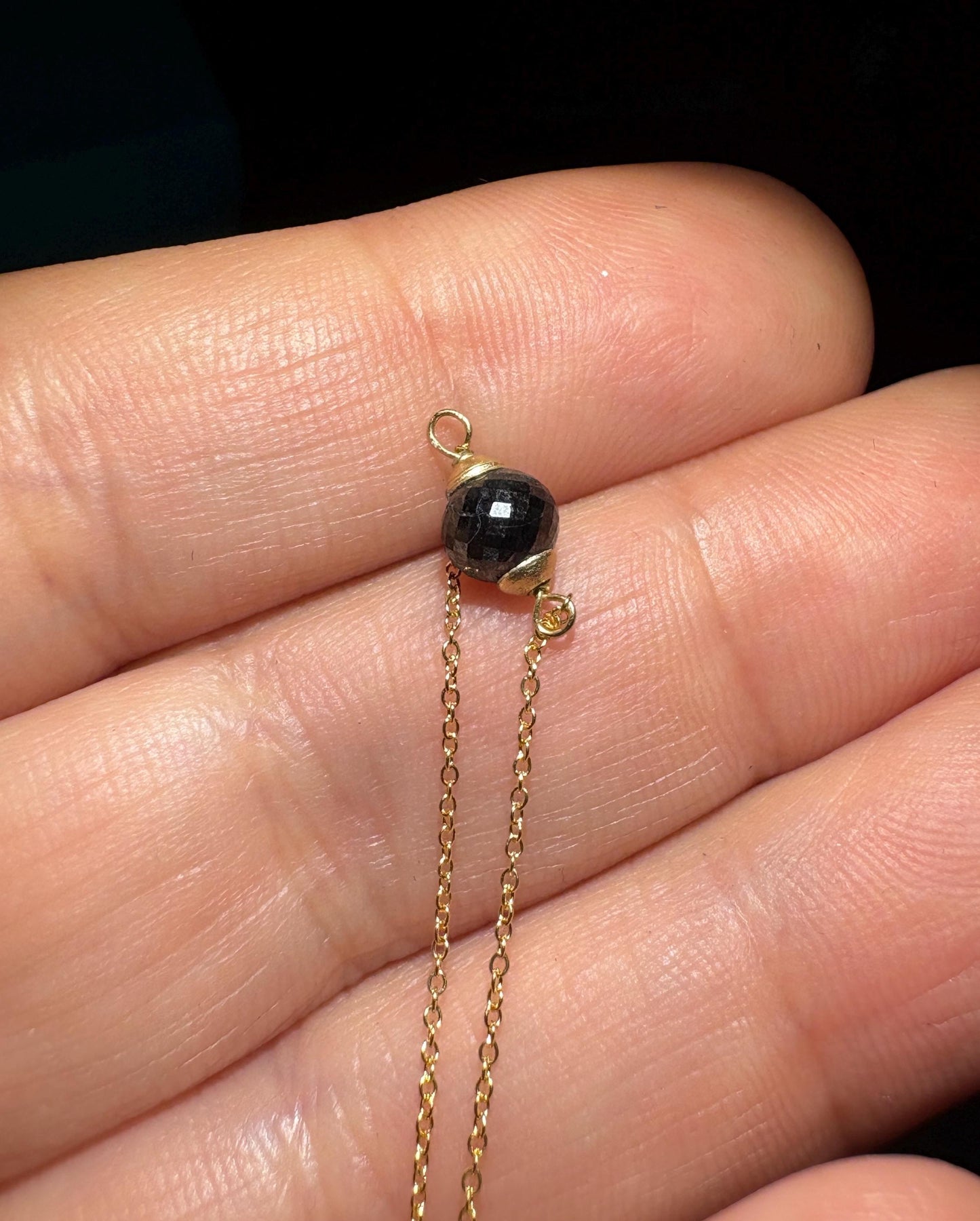 Solid 14k gold bracelet with a faceted black diamond bead.