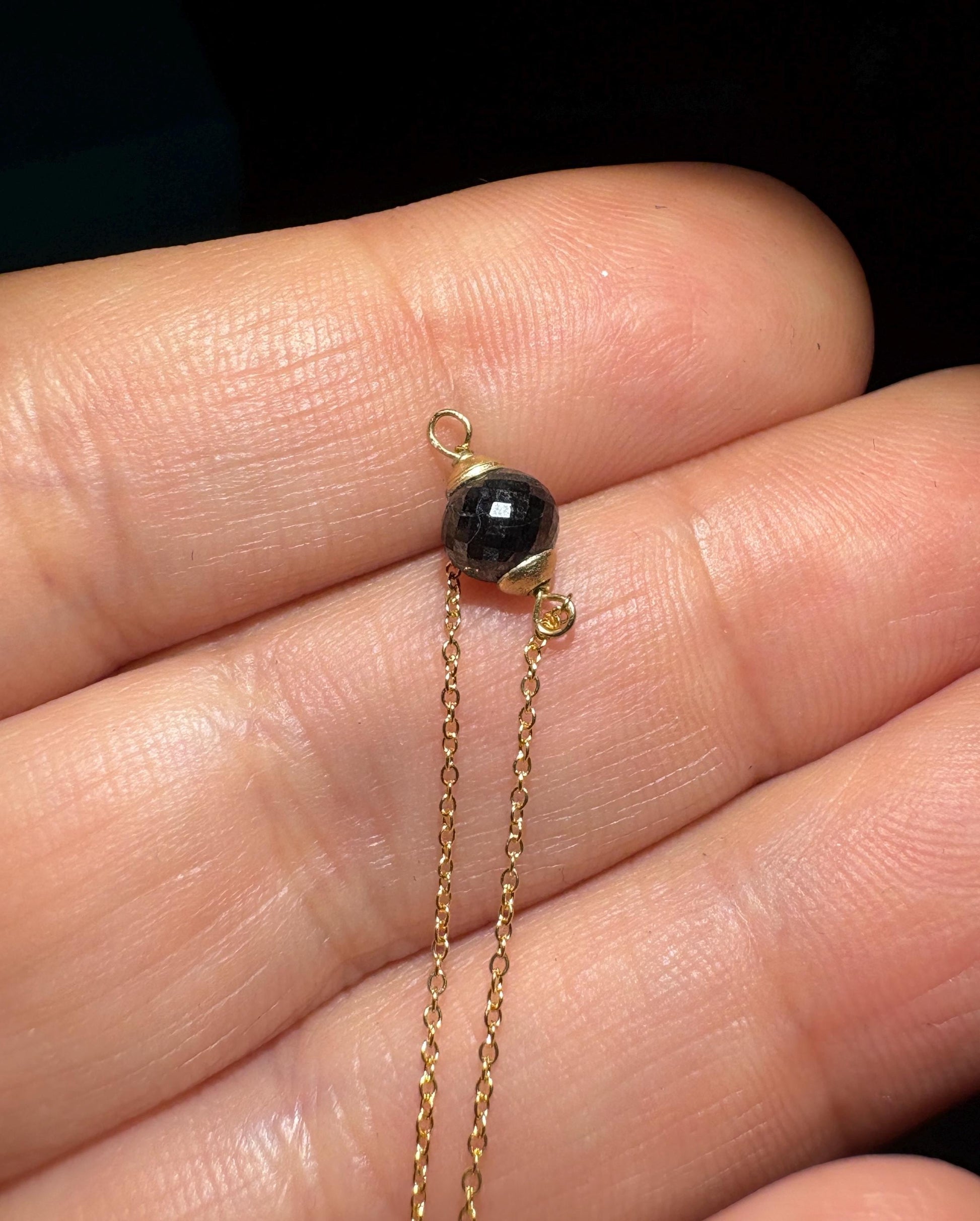 Solid 14k gold bracelet with a faceted black diamond bead.
