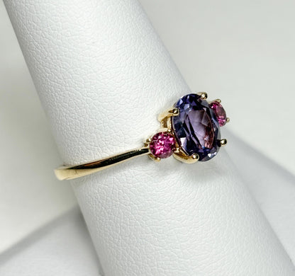 A 10k gold ring with a color-change synthetic sapphire and two umbalite garnets.