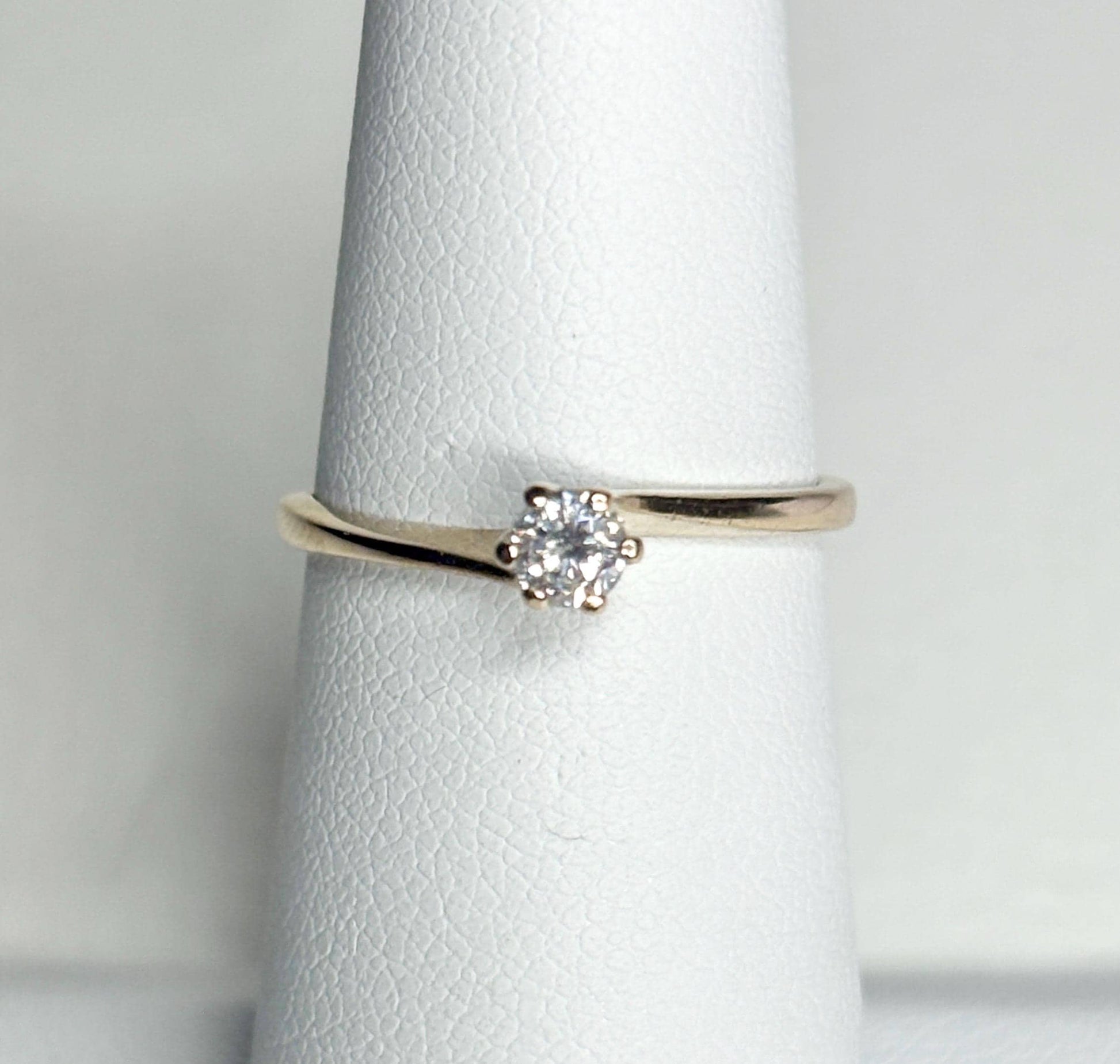 A 14k gold ring with a .15ct diamond in a twist design.