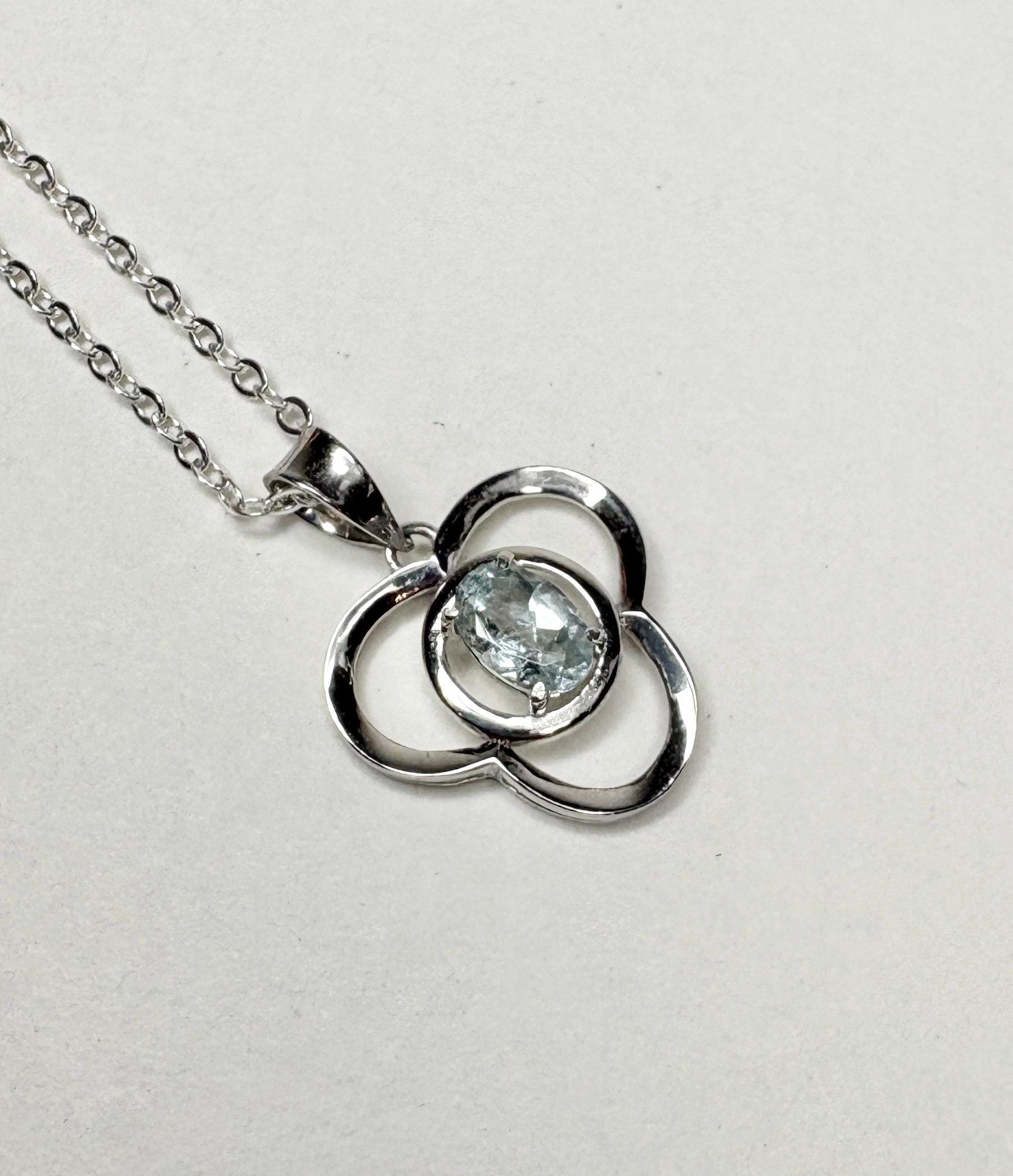 Sterling silver pendant necklace with a clover design and a light blue oval tourmaline.