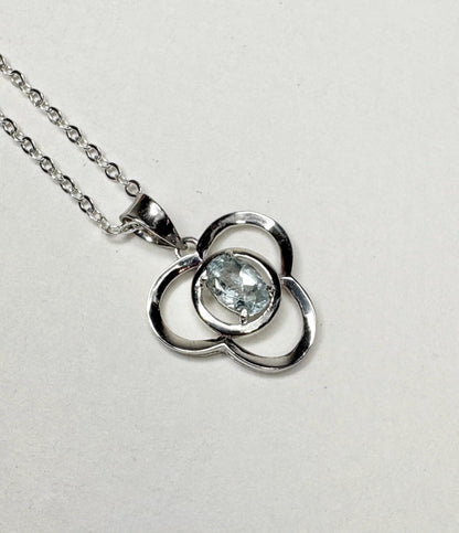 Sterling silver pendant necklace with a clover design and a light blue oval tourmaline.