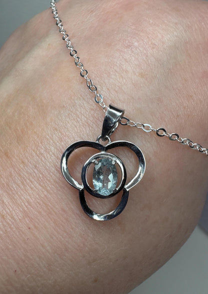 Sterling silver pendant necklace with a clover design and a light blue oval tourmaline.