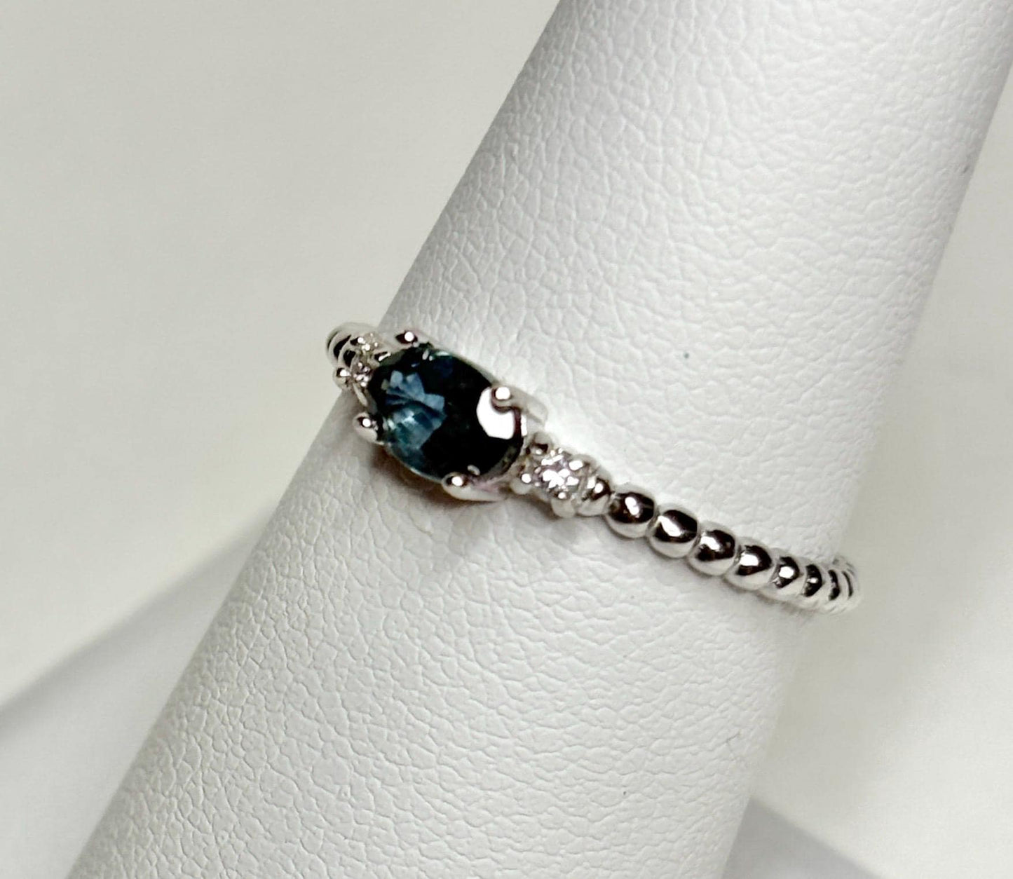 Sterling silver ring with oval Montana sapphire and diamonds on a beaded band.