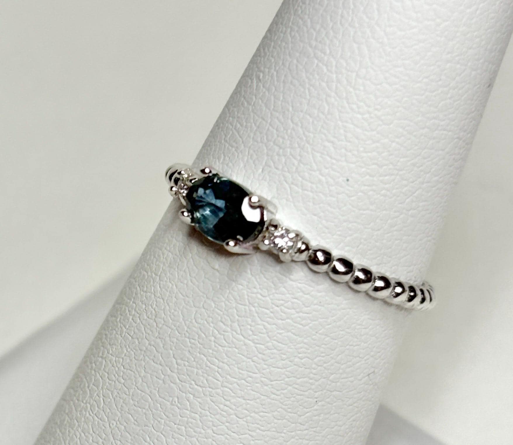 Sterling silver ring with oval Montana sapphire and diamonds on a beaded band.