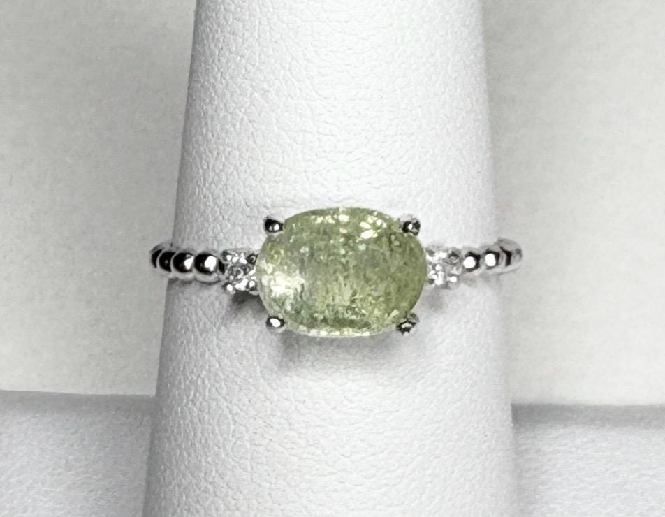 Sterling silver ring with a green oval tourmaline and two small diamonds.