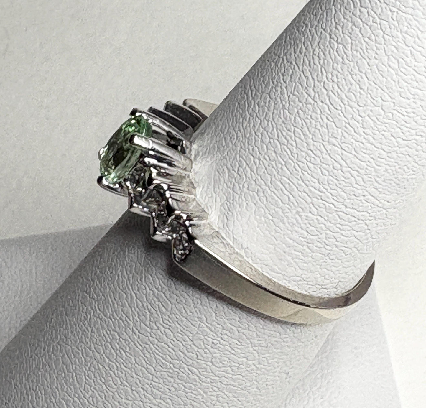 14k white gold ring with a green tourmaline and diamonds.