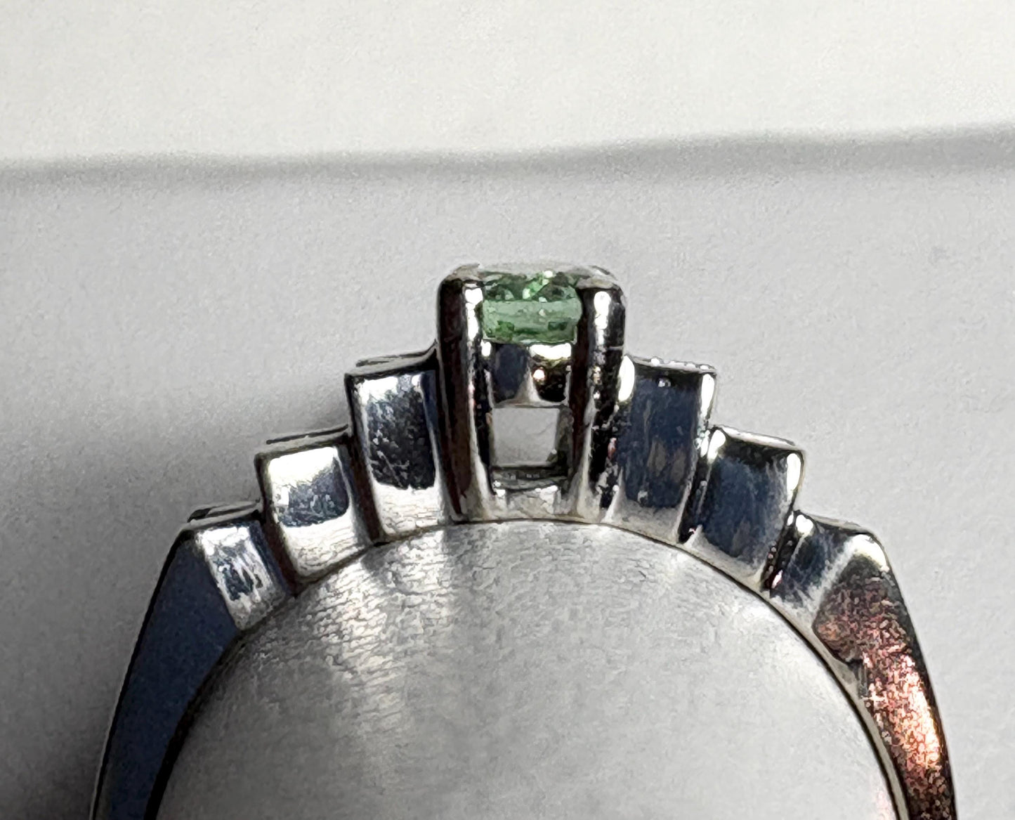 14k white gold ring with a green tourmaline and diamonds.