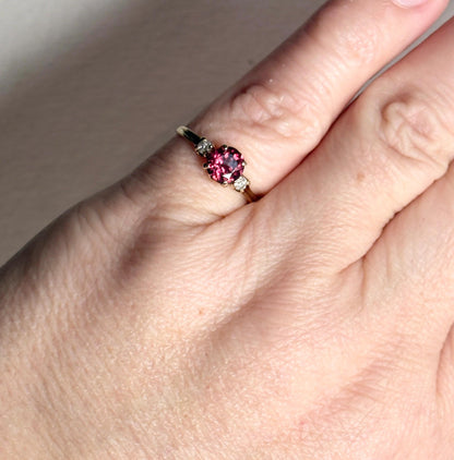 A vintage 10k gold ring with a merlot garnet and two diamonds.