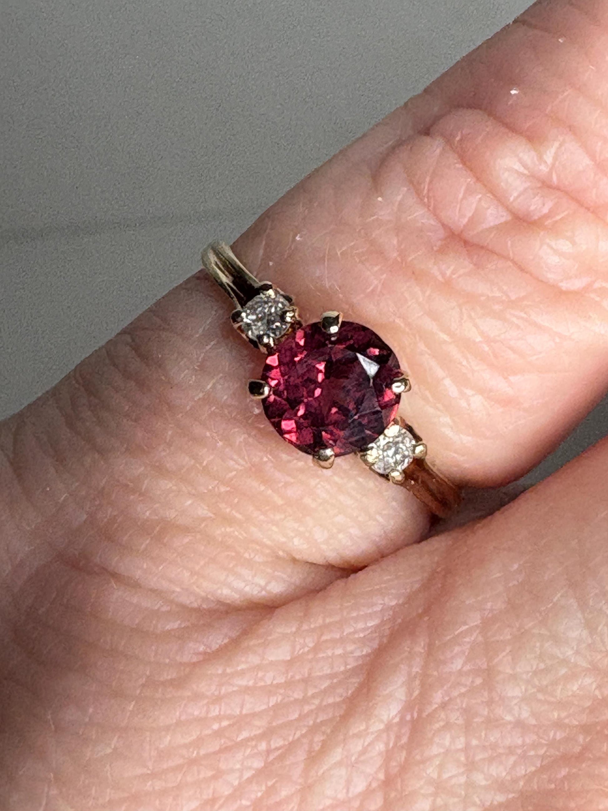A vintage 10k gold ring with a merlot garnet and two diamonds.