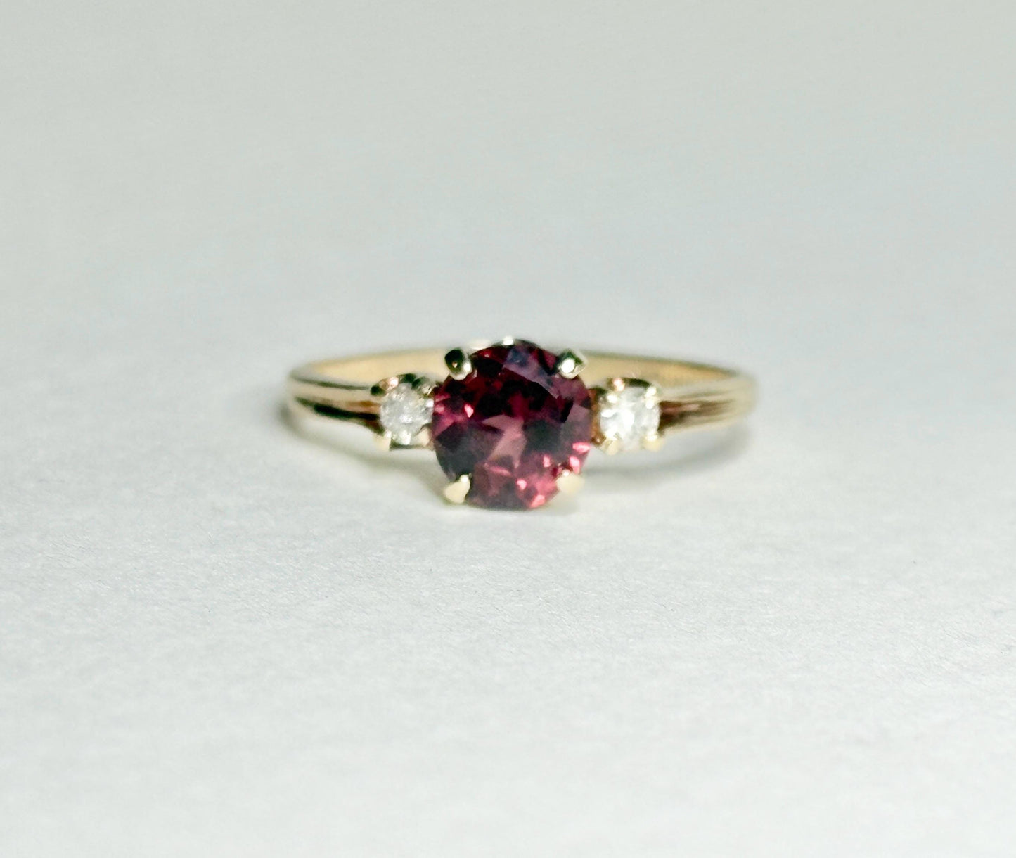 A 10k gold ring with a merlot garnet and two diamonds.